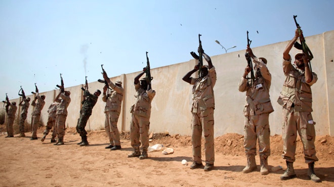 Libyan rebels fire into sky during funeral.jpg